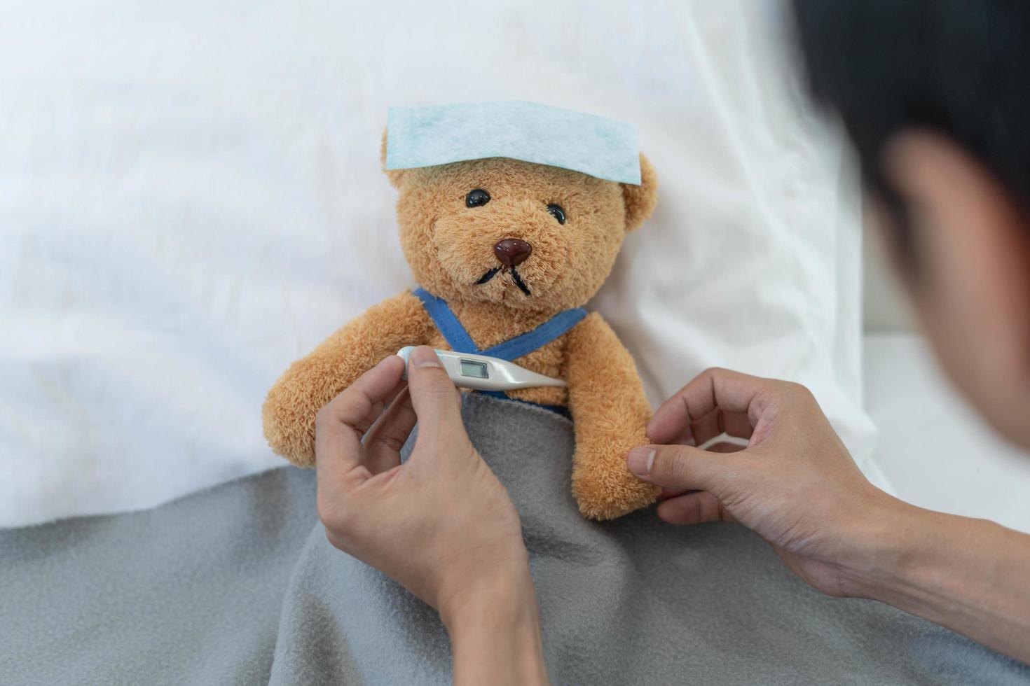 Teddy bear and bandage with thermometer. sick and injury concept photo