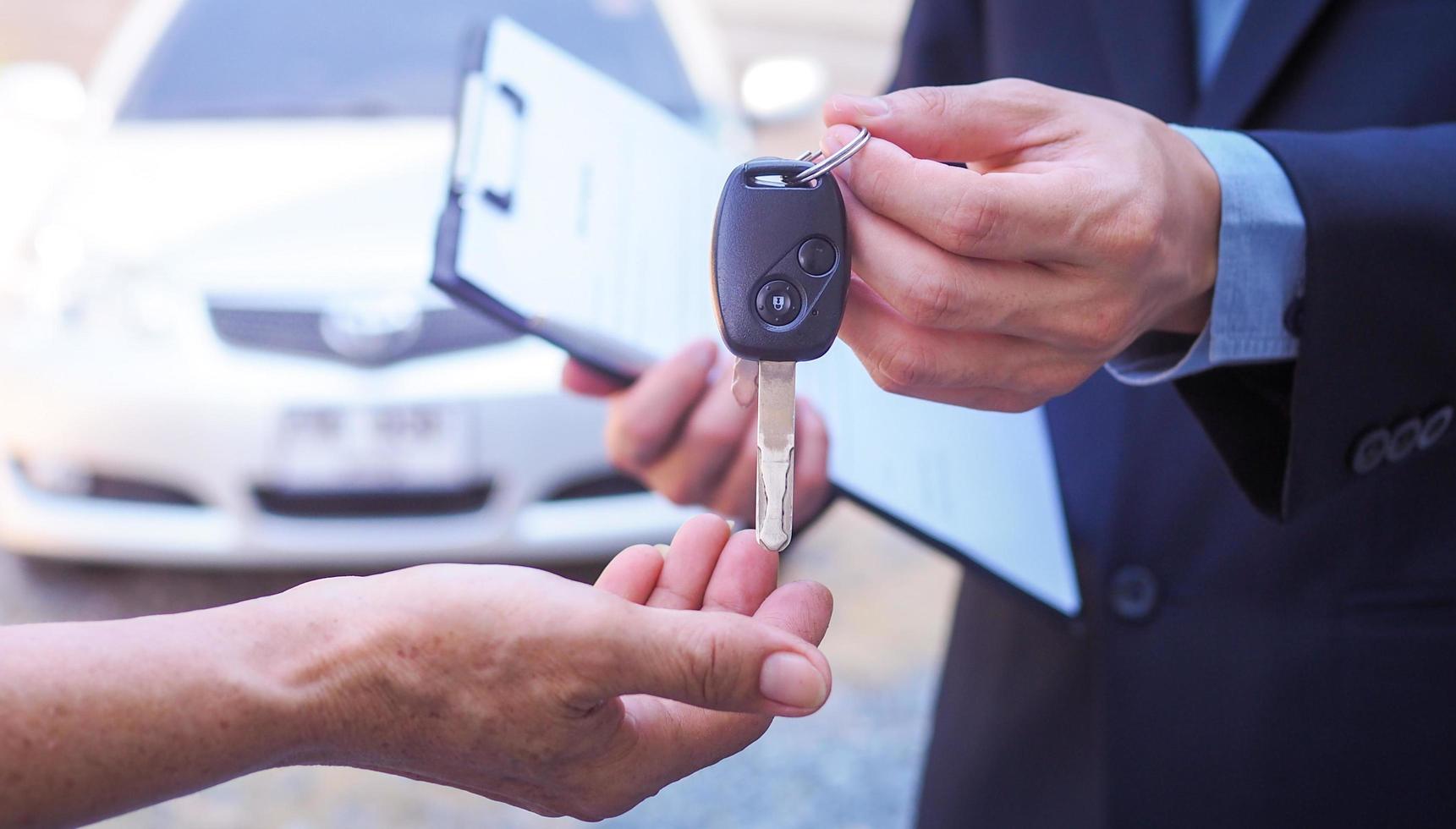 The car salesman and the key to the new owner. photo