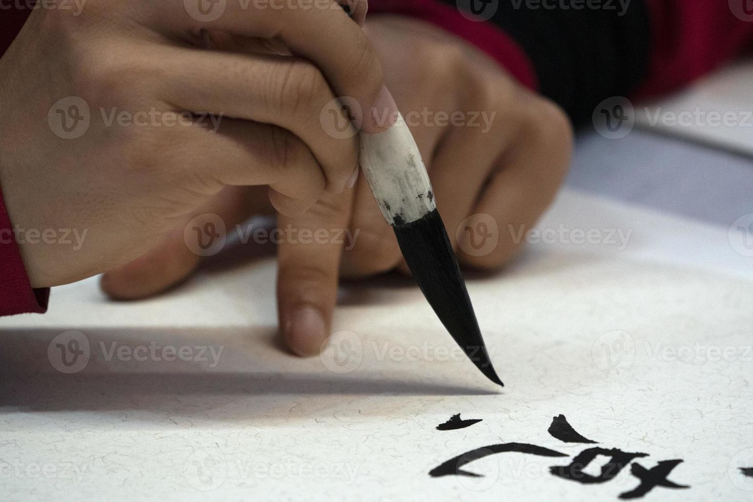 japanese woman writing ideograms with brush photo