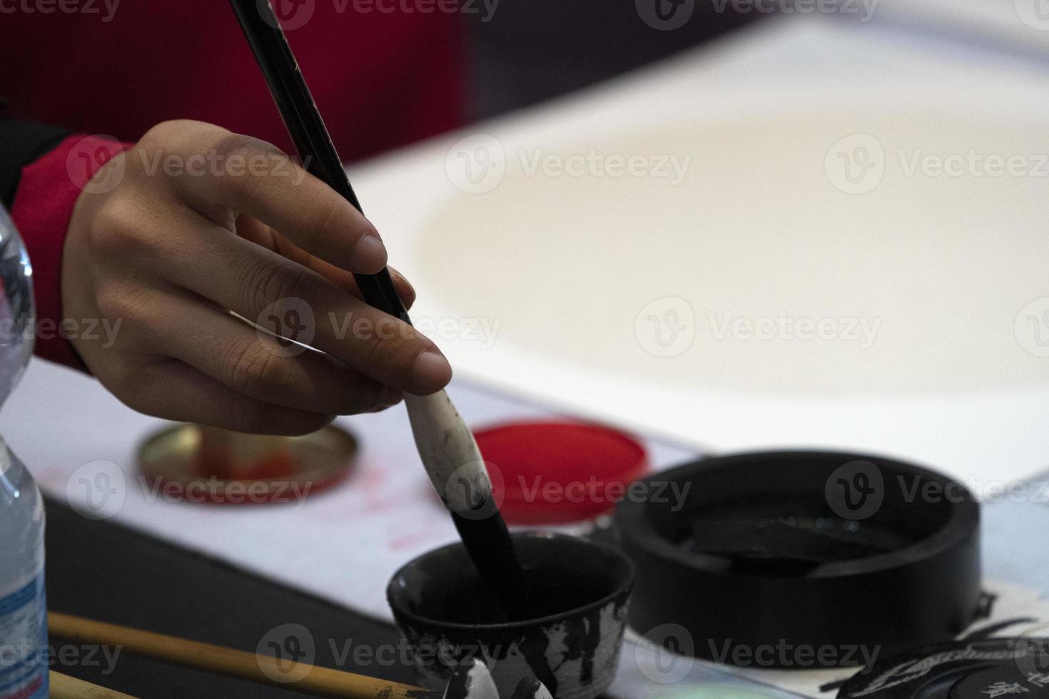 japanese woman writing ideograms with brush photo