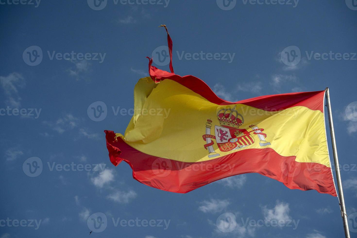 ondeando la bandera de españa en el cielo azul foto