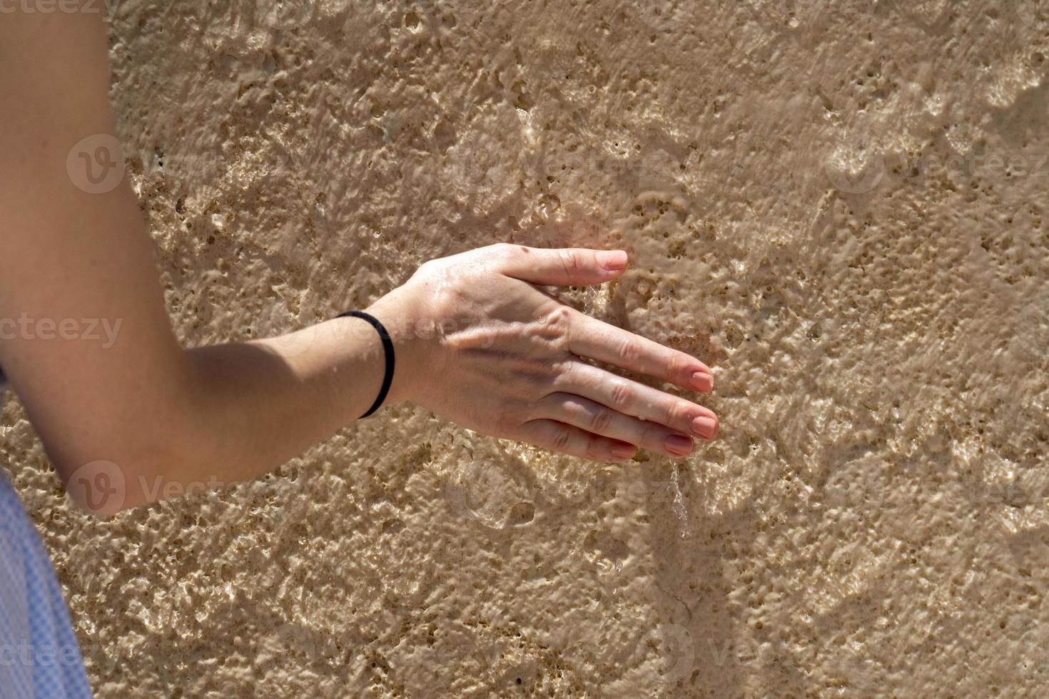 Woman hand on wet wall photo