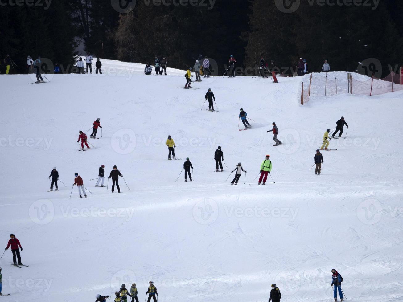 many skiers skiing in dolomites gardena valley snow mountains photo