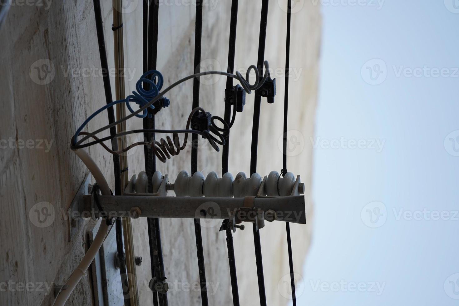 cables eléctricos de malta colgando del edificio foto