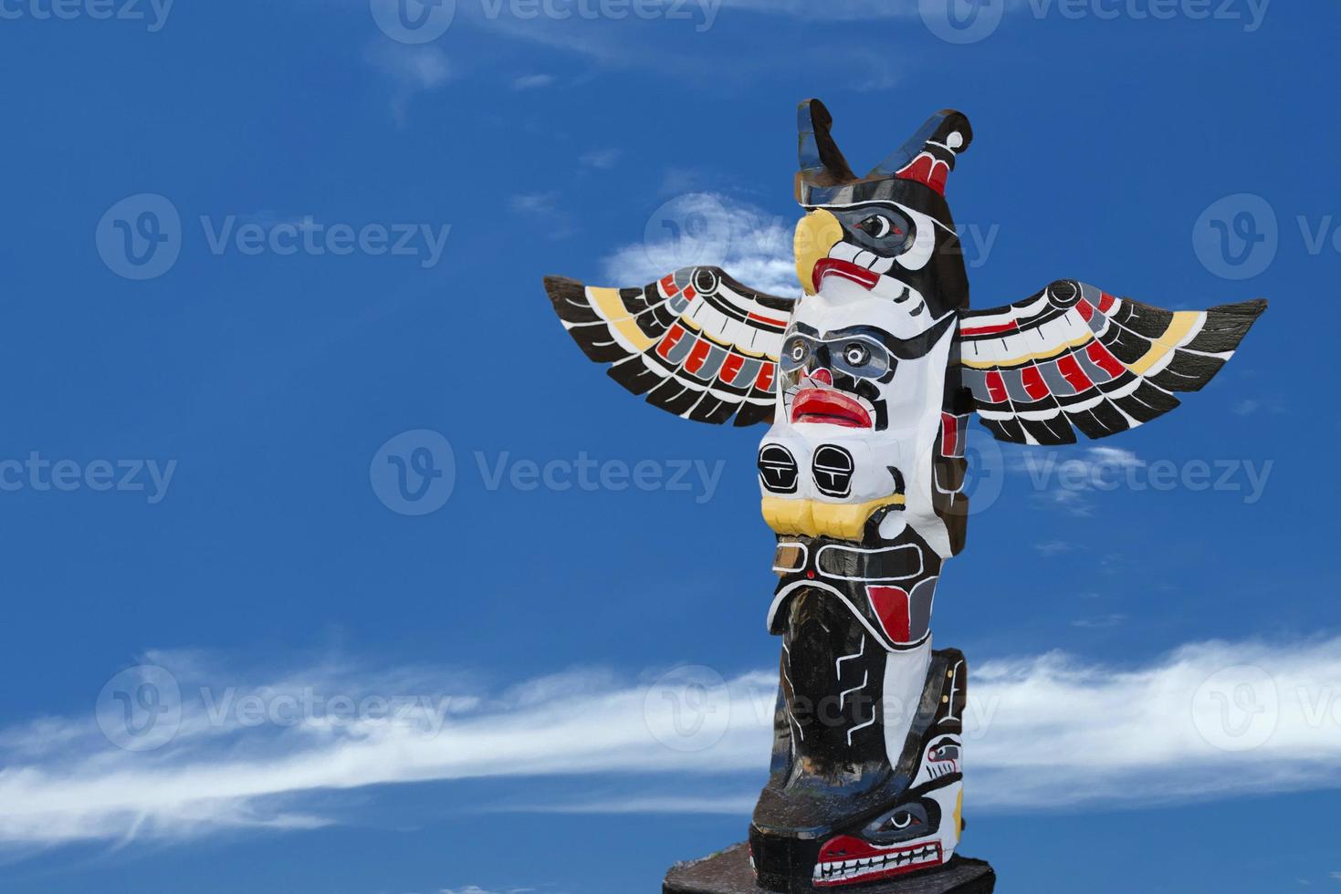 A totem wood pole in the blue cloudy background photo