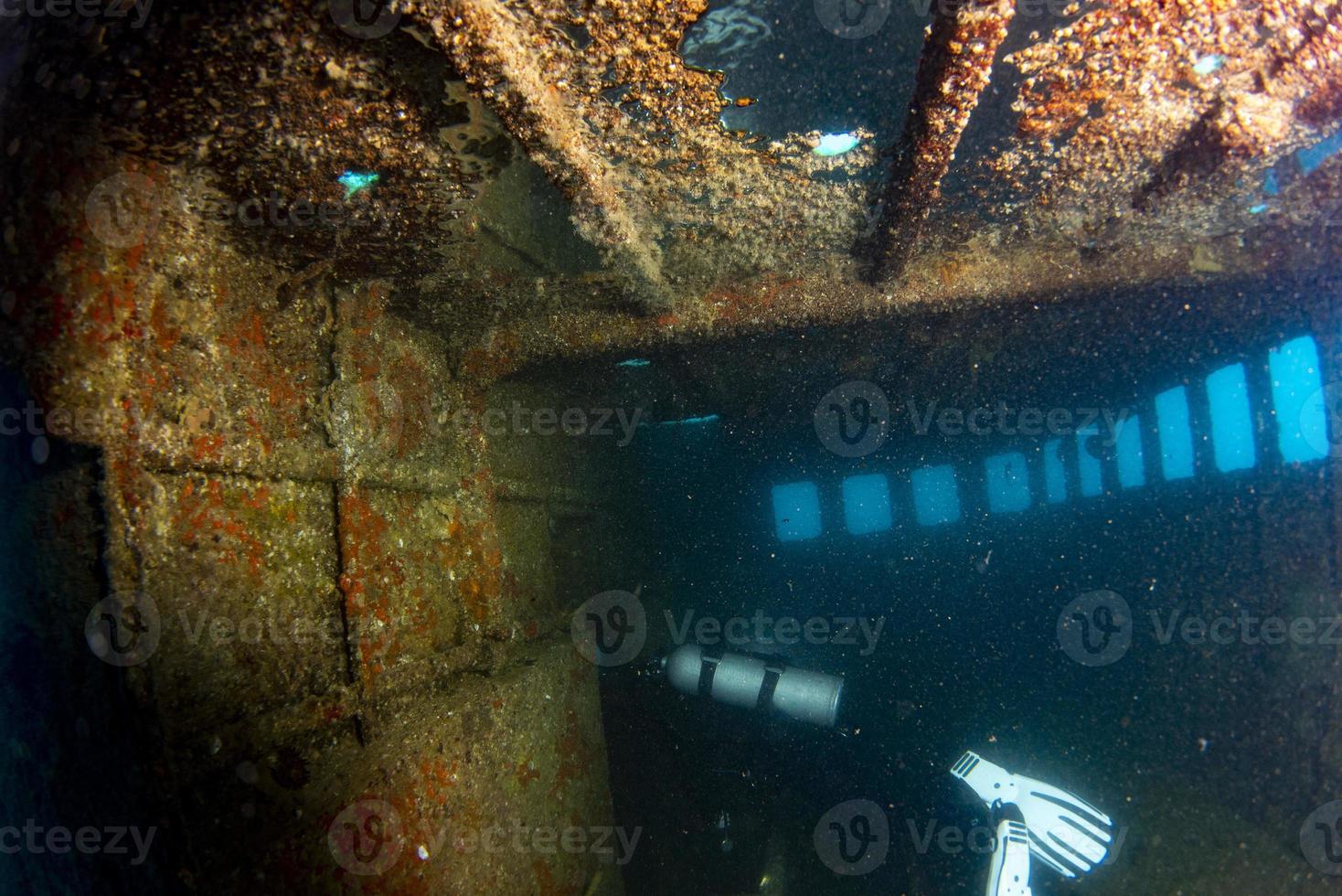 divers exploring a shipwreck underwater photo