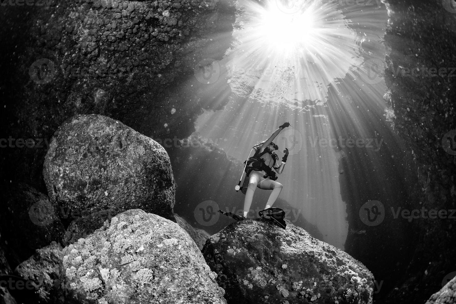 beautiful diver underwater with sun rays photo