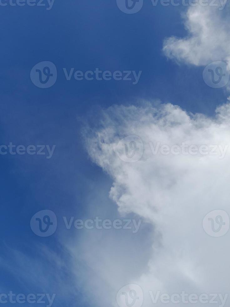 Beautiful white clouds on deep blue sky background. Elegant blue sky picture in daylight. Large bright soft fluffy clouds are cover the entire blue sky. photo