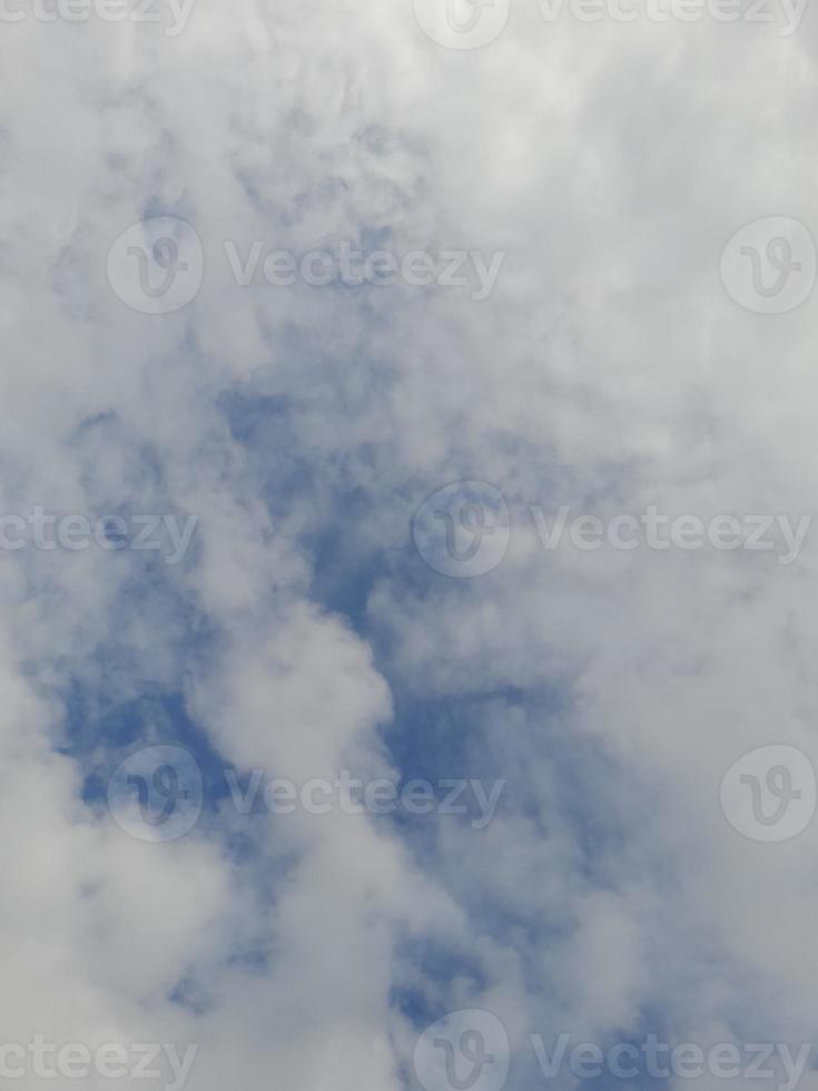 White clouds in the blue sky. Heaven and infinity. Beautiful bright blue background. Light cloudy, good weather. Curly clouds on a sunny day. photo