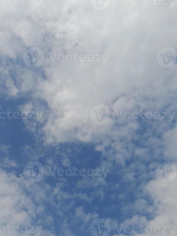 Beautiful white clouds on deep blue sky background. Elegant blue sky picture in daylight. Large bright soft fluffy clouds are cover the entire blue sky. photo