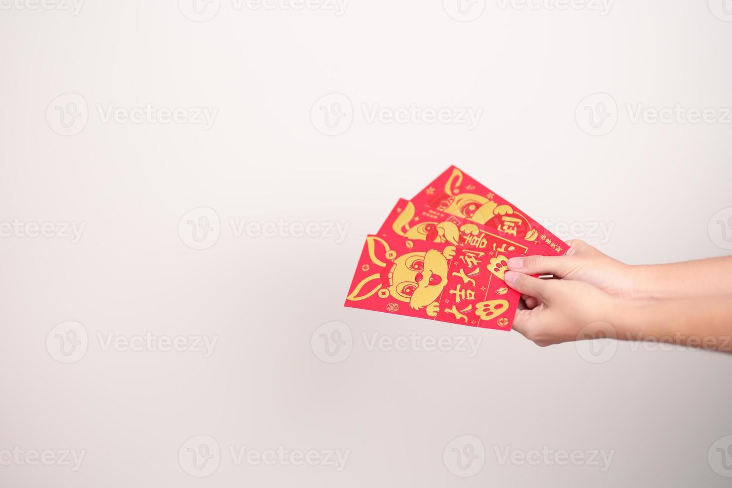 woman holding Chinese red envelope with golden rabbit and blessing word, money gift for happy Lunar New Year holiday. Chinese sentence means happiness, healthy, Lucky and Wealthy photo