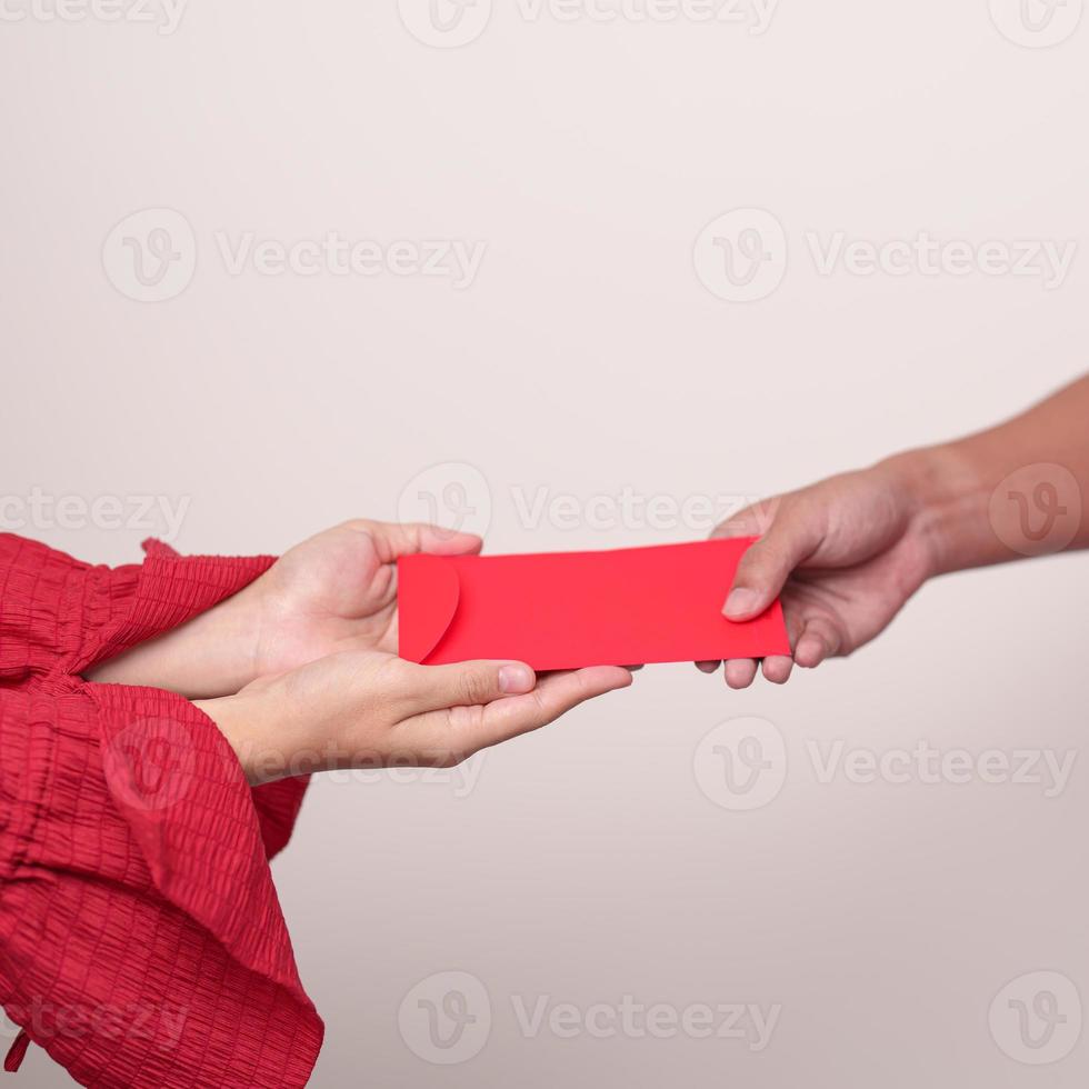 People hand giving Chinese red envelope, money gift for happy Lunar New Year holiday photo