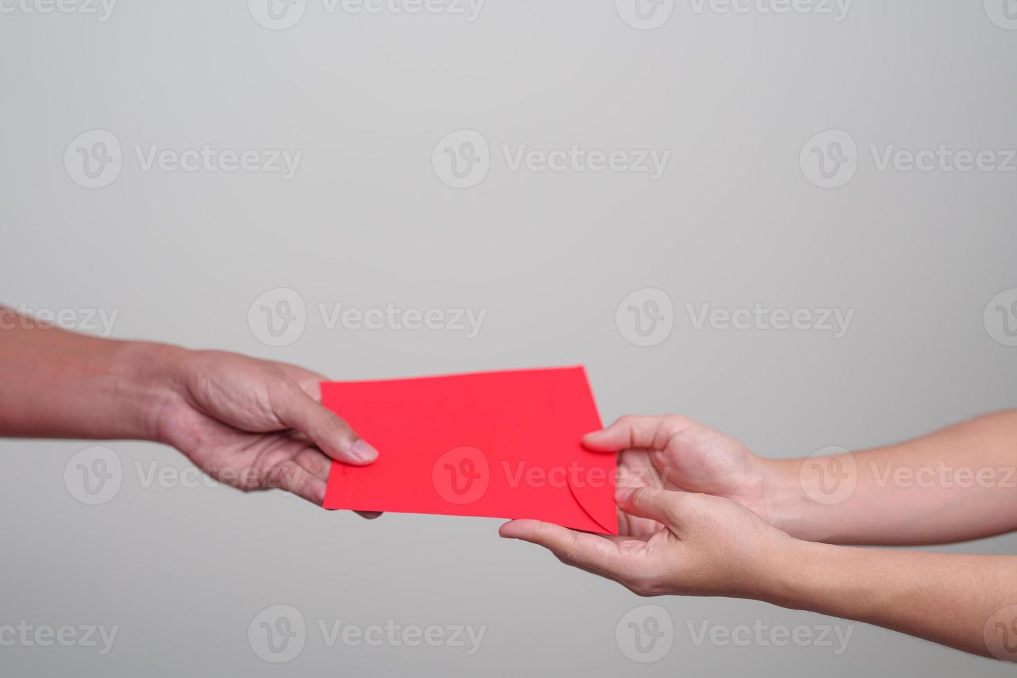 People hand giving Chinese red envelope, money gift for happy Lunar New Year holiday photo