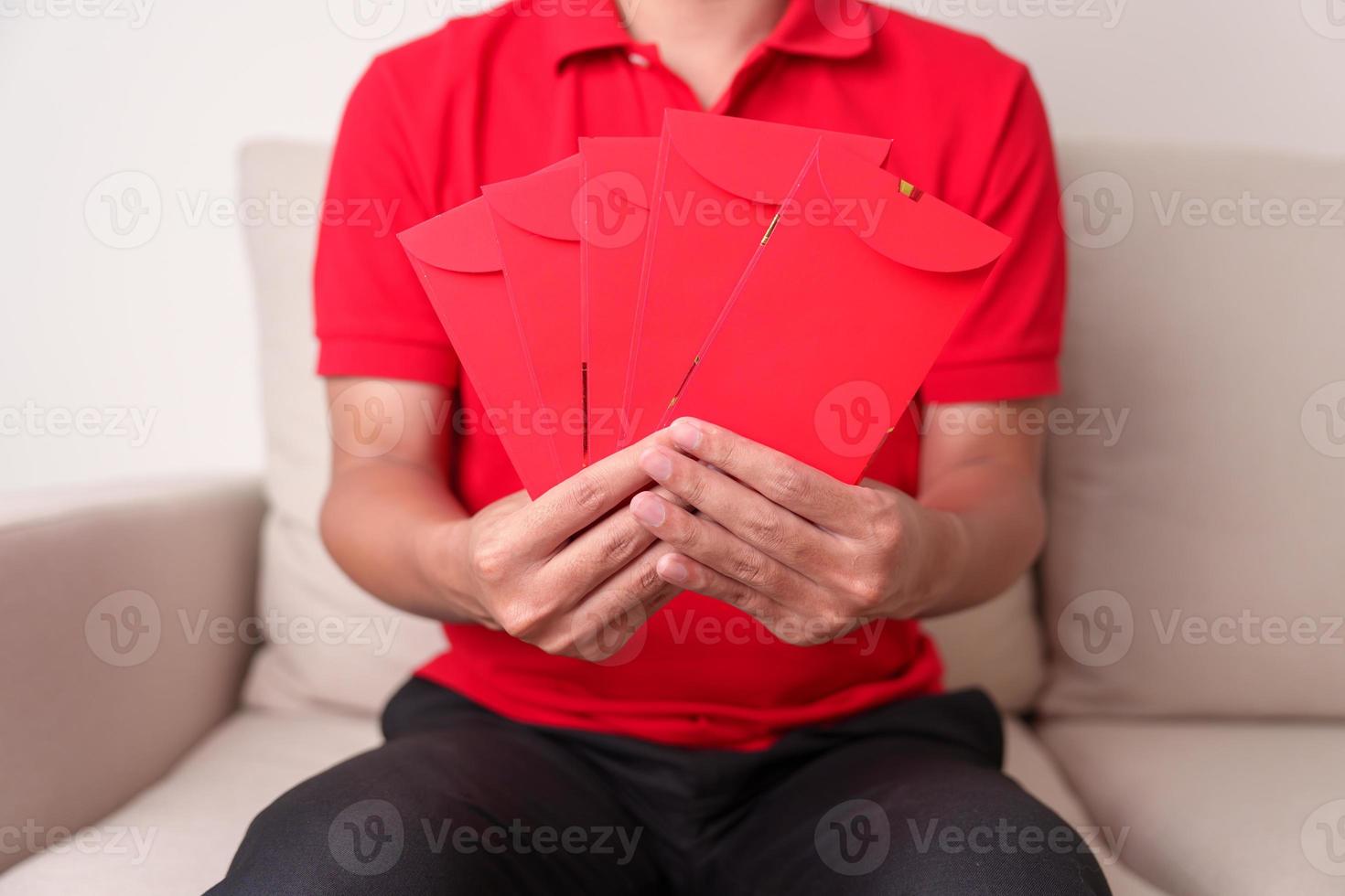 man holding Chinese red envelope, money gift for happy Lunar New Year holiday photo