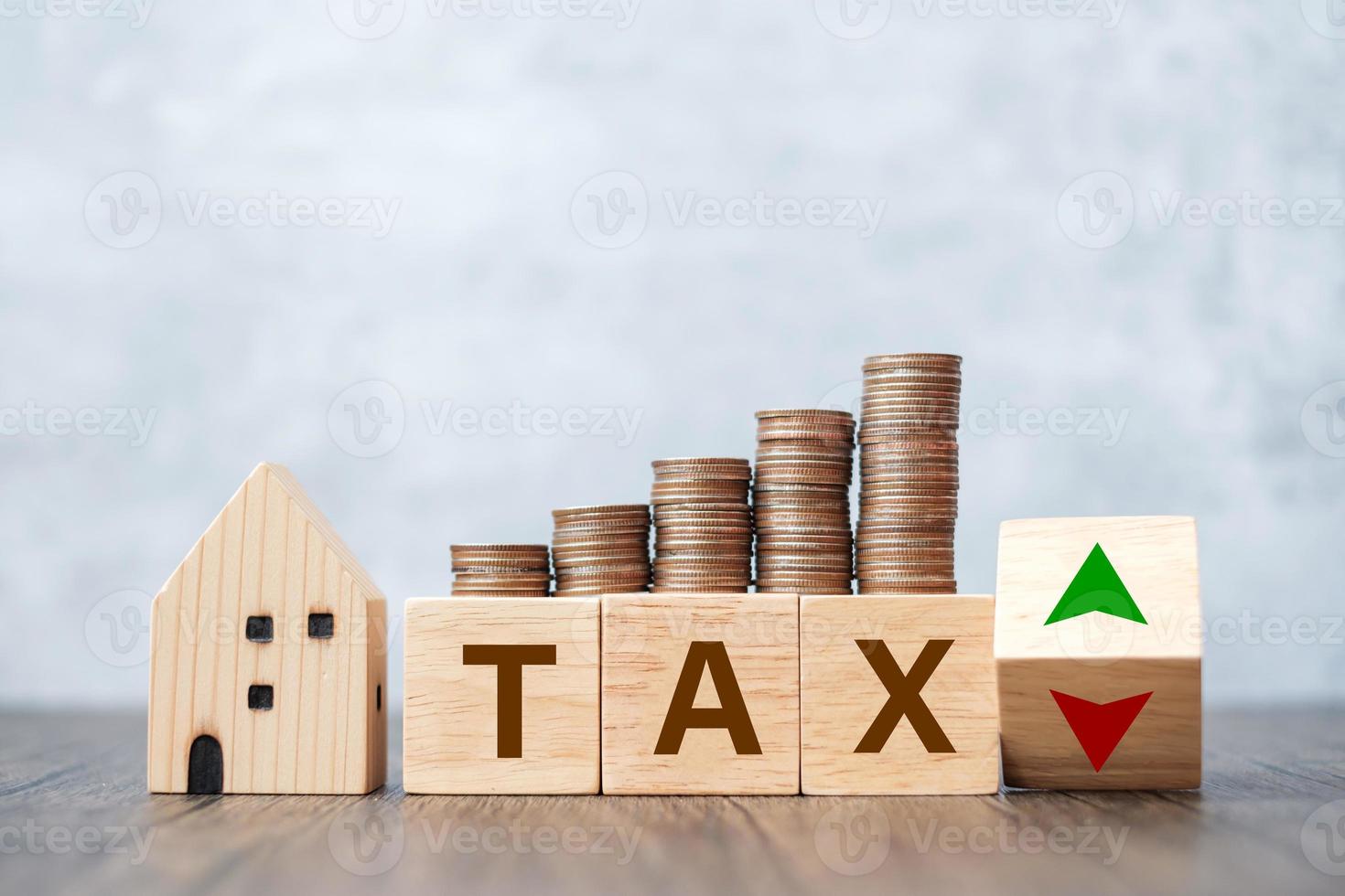TAX block with house model and coin money stack. real estate, Home loan, taxation, payment and financial concept photo