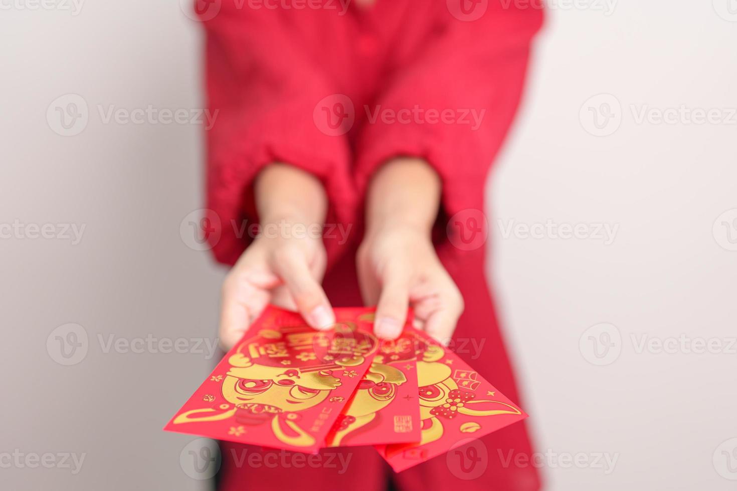 woman holding Chinese red envelope with golden rabbit and blessing word, money gift for happy Lunar New Year holiday. Chinese sentence means happiness, healthy, Lucky and Wealthy photo