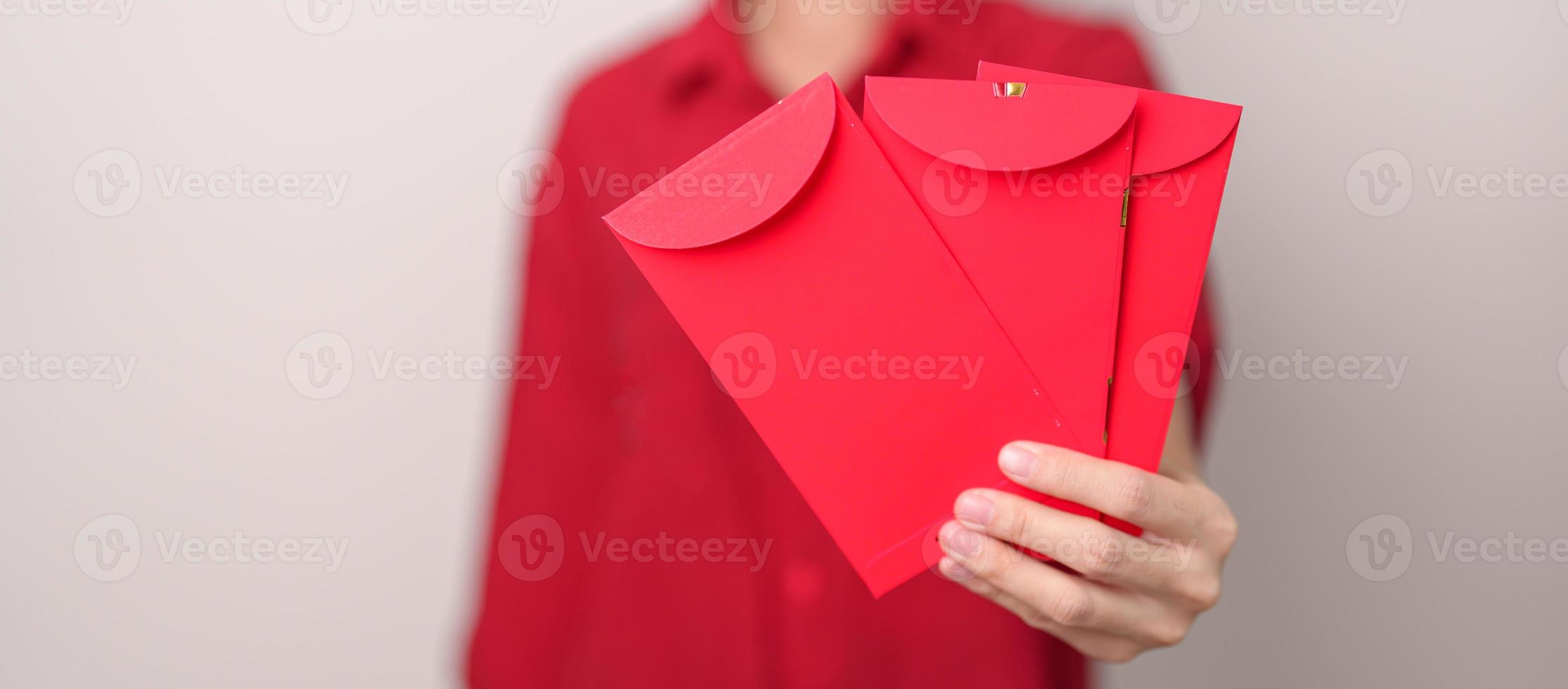 Woman holding Chinese red envelope, money gift for happy Lunar New Year holiday photo