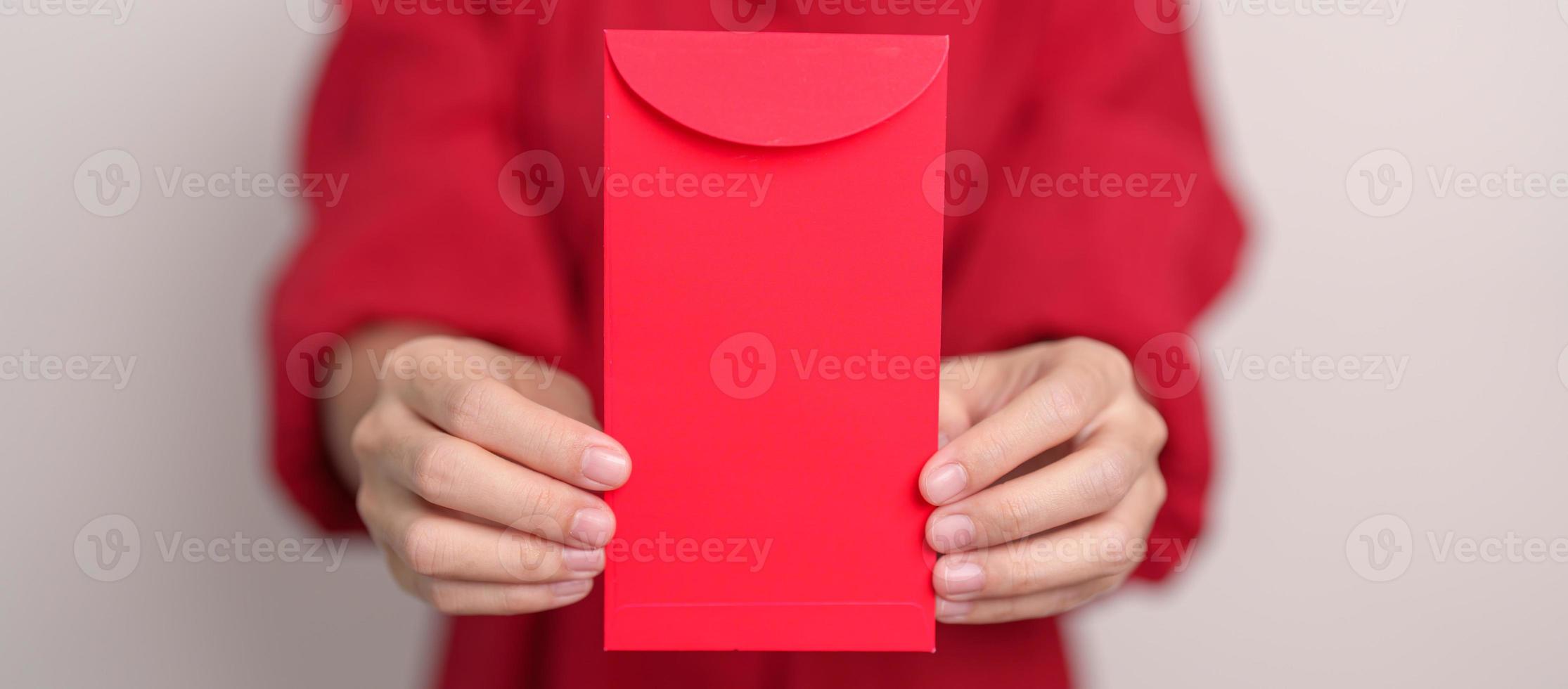 Woman holding Chinese red envelope, money gift for happy Lunar New Year holiday photo