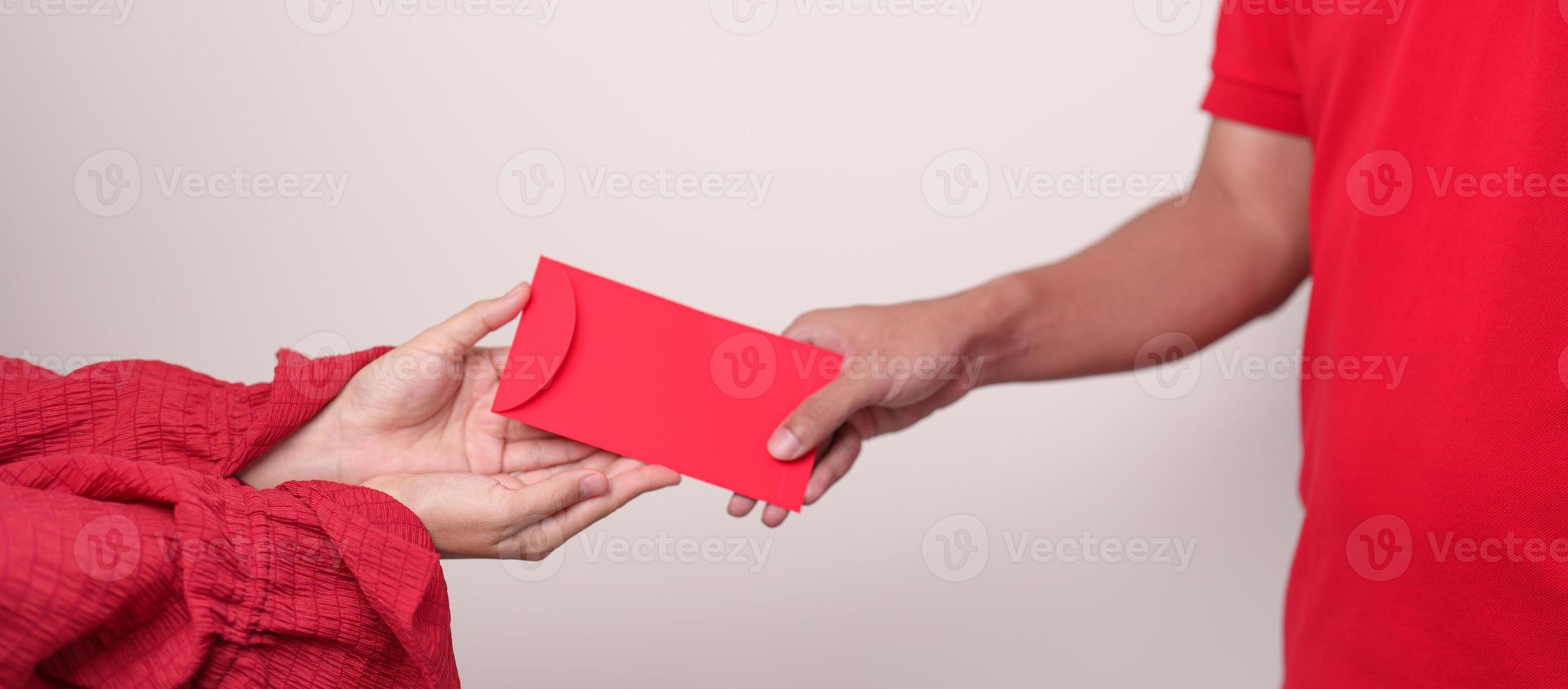 People hand giving Chinese red envelope, money gift for happy Lunar New Year holiday photo