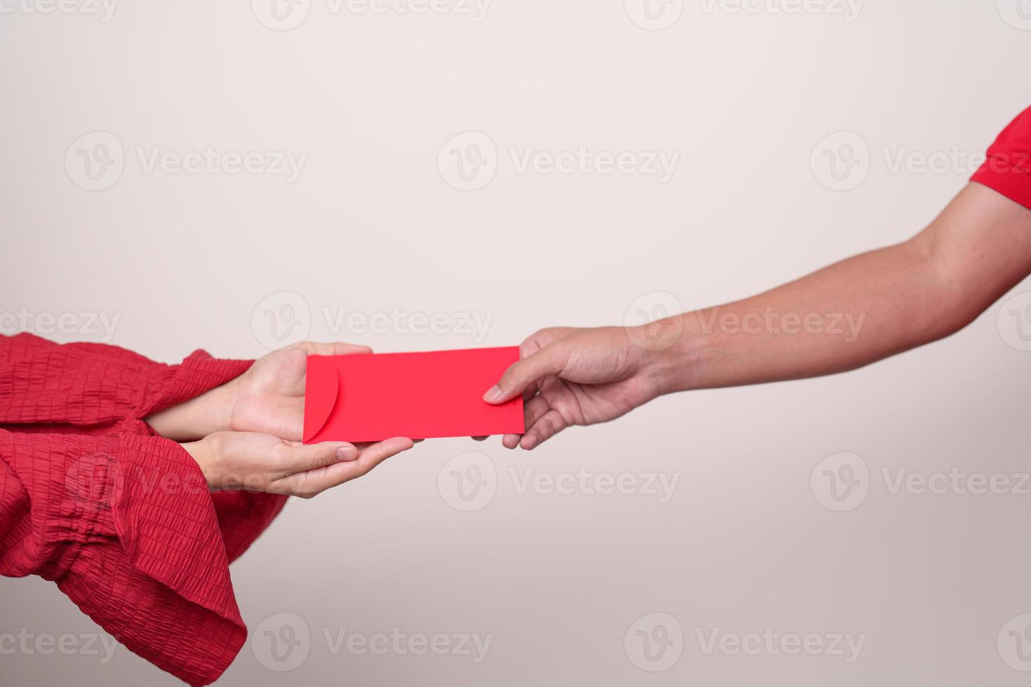 People hand giving Chinese red envelope, money gift for happy Lunar New Year holiday photo
