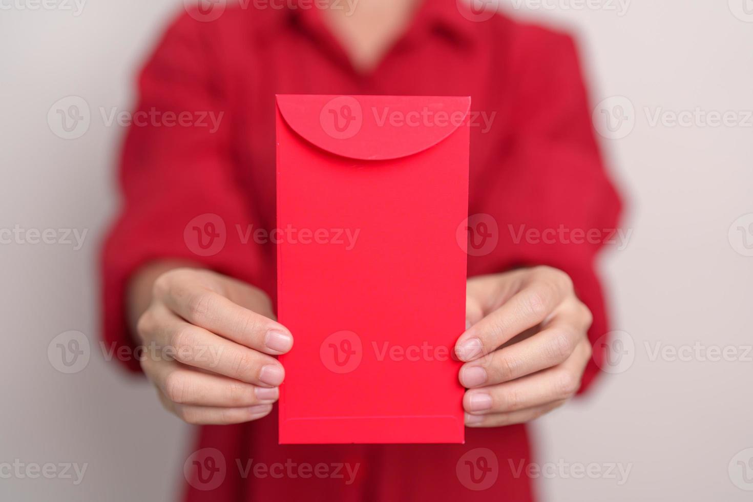 Woman holding Chinese red envelope, money gift for happy Lunar New Year holiday photo