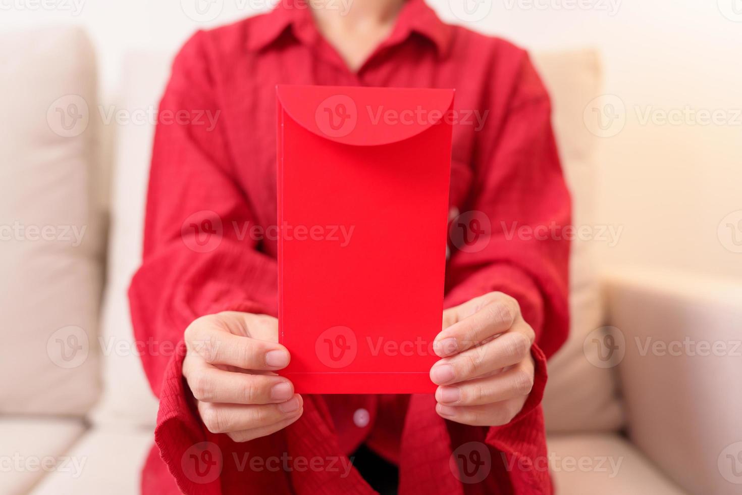 Woman holding Chinese red envelope, money gift for happy Lunar New Year holiday photo