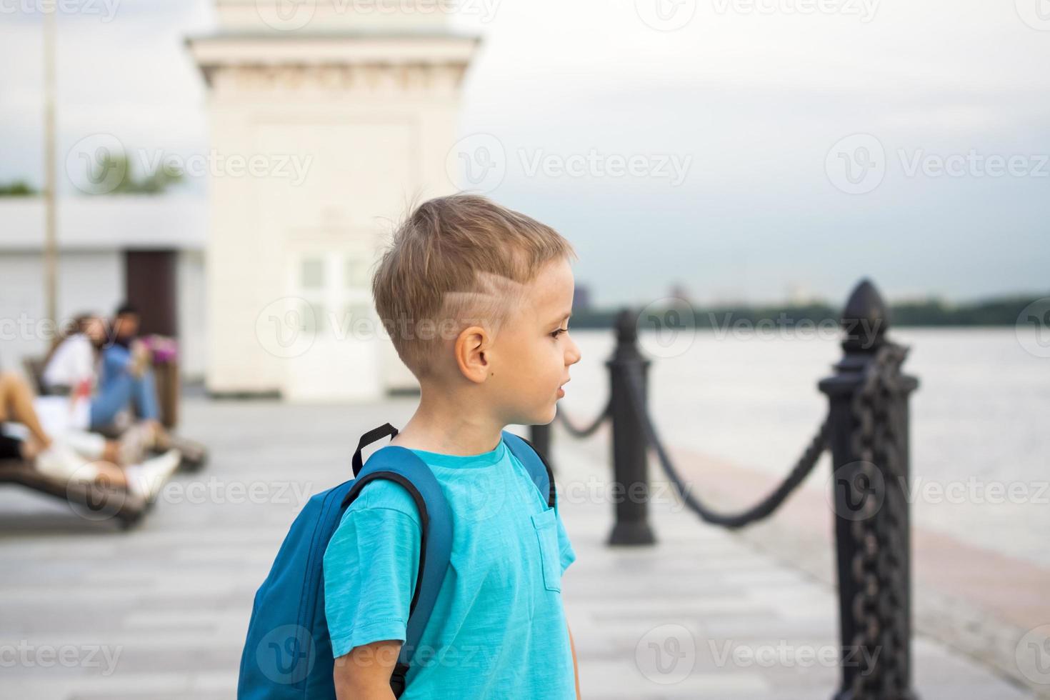 A boy in a blue T-shirt with a backpack on his back. Journey.  The face expresses natural joyful emotions. Not staged photos from nature