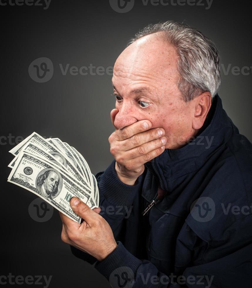 elderly man with fan of dollars photo