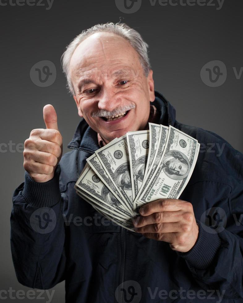 Happy elderly man showing fan of money photo