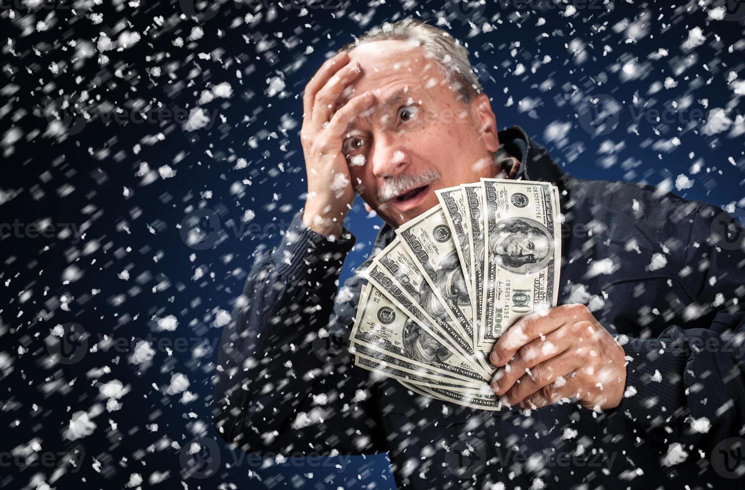 man with a bundle of dollars in snowfall photo