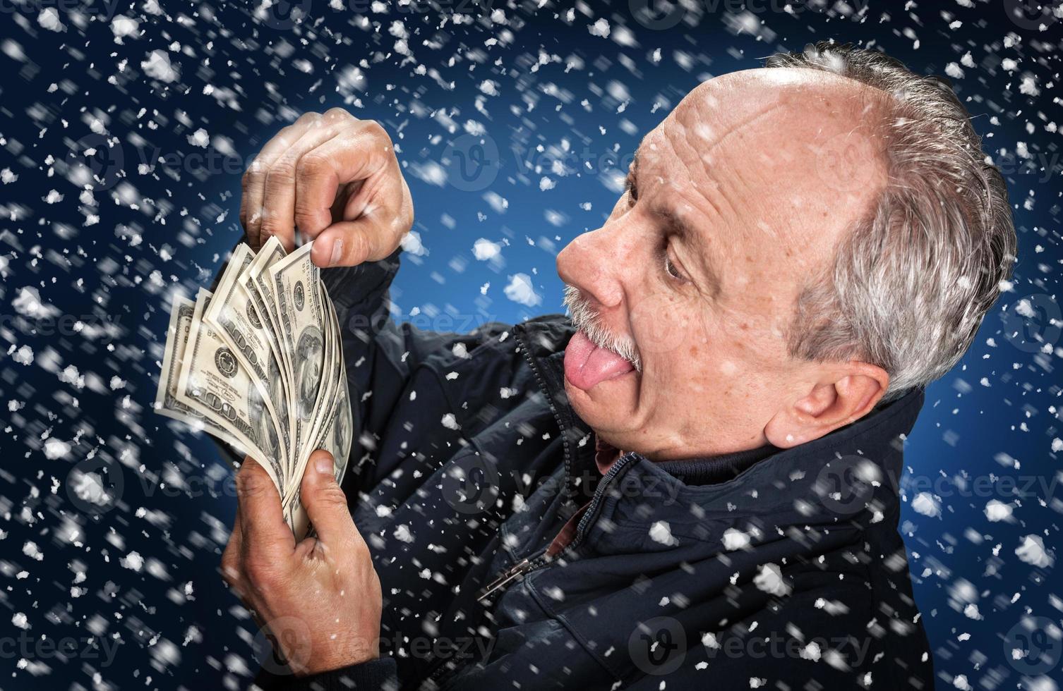 man with a bundle of dollars in snowfall photo