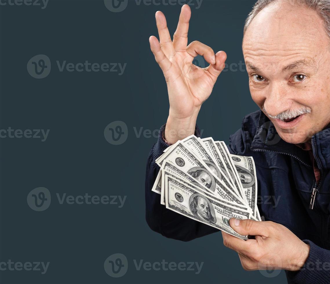 elderly man showing fan of money photo