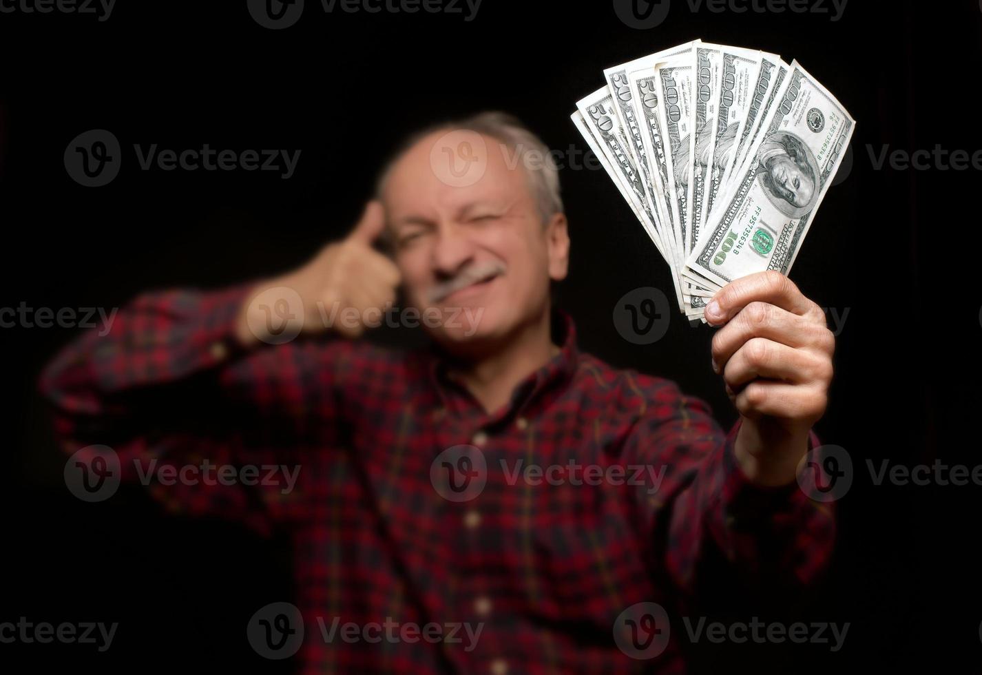 anciano mostrando abanico de dinero foto