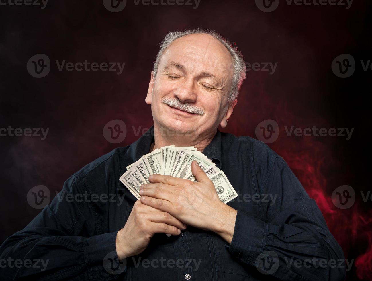 old man holding dollar bills photo