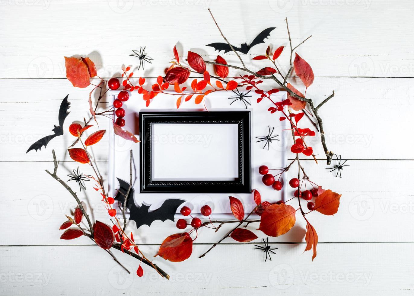 Halloween mock up template black frame, fall red branches, spiders, bats on white wooden backdrop. photo