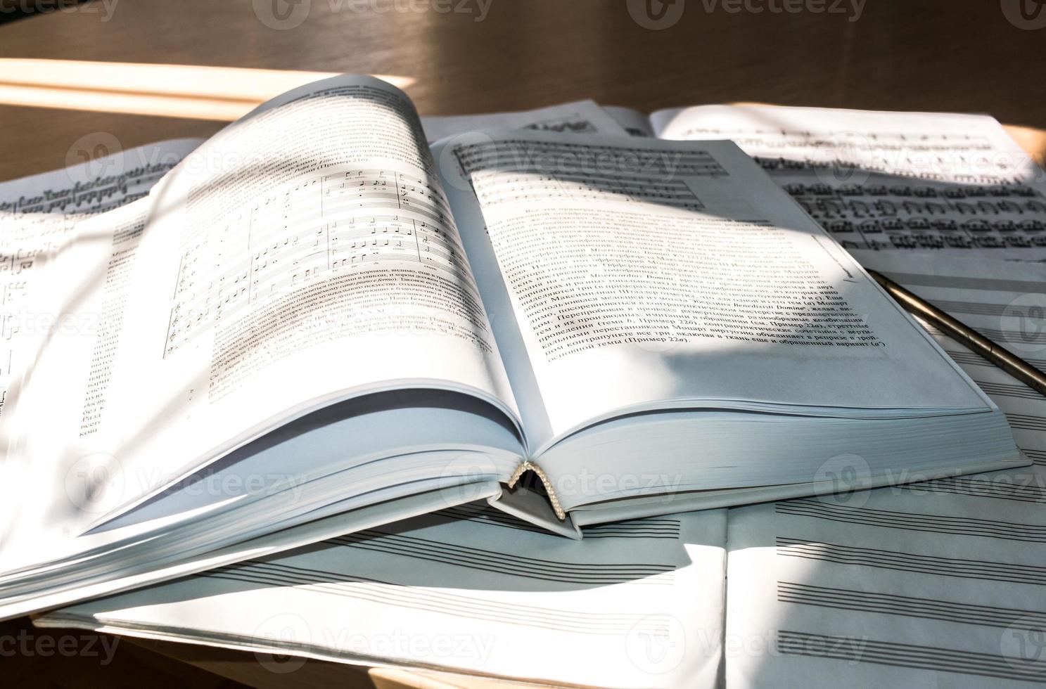 Flooded with light  open book, sheet music and music notebook. photo