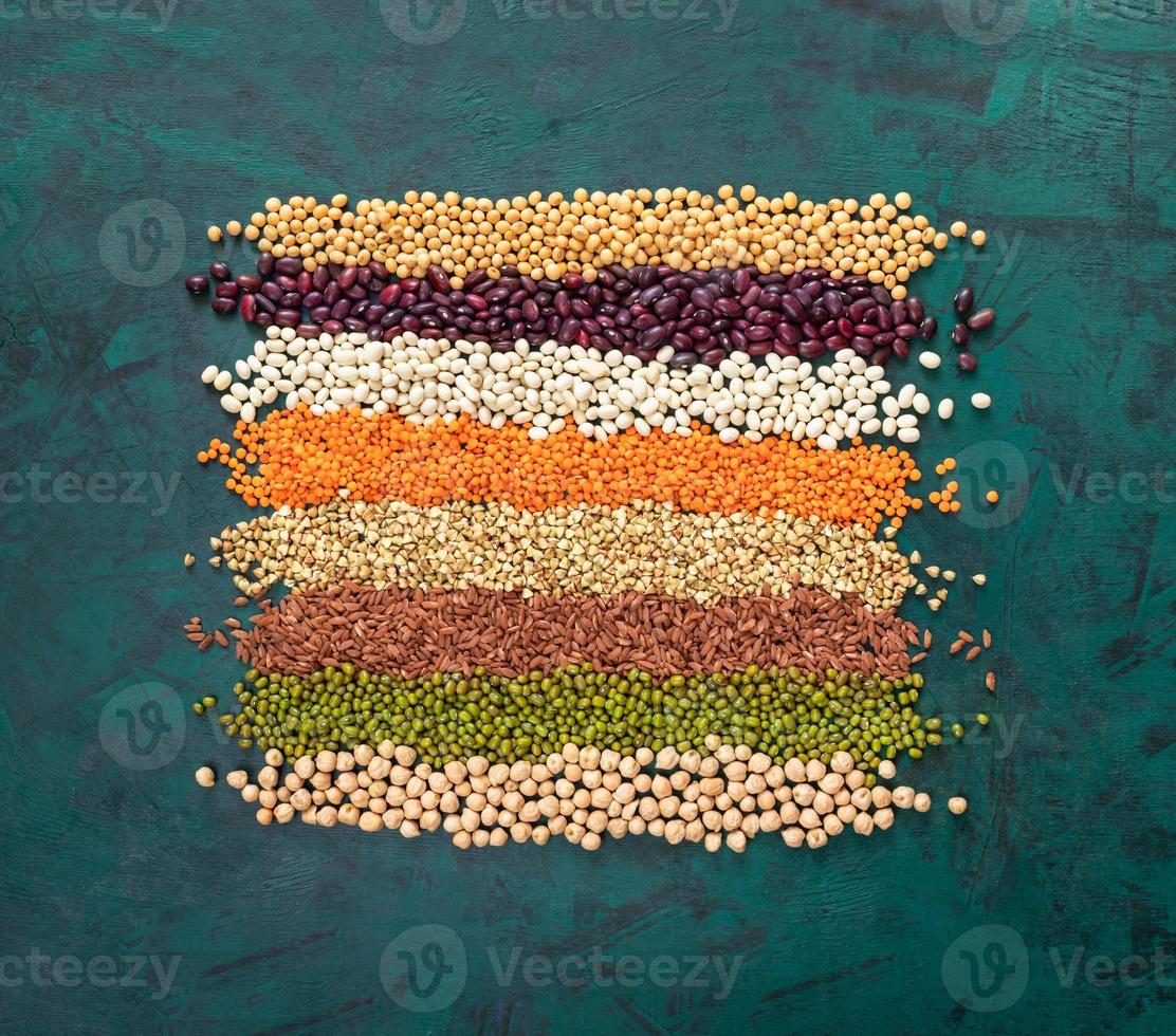 Square of superfoods laid out stripes, in middle of textured emerald green background. photo