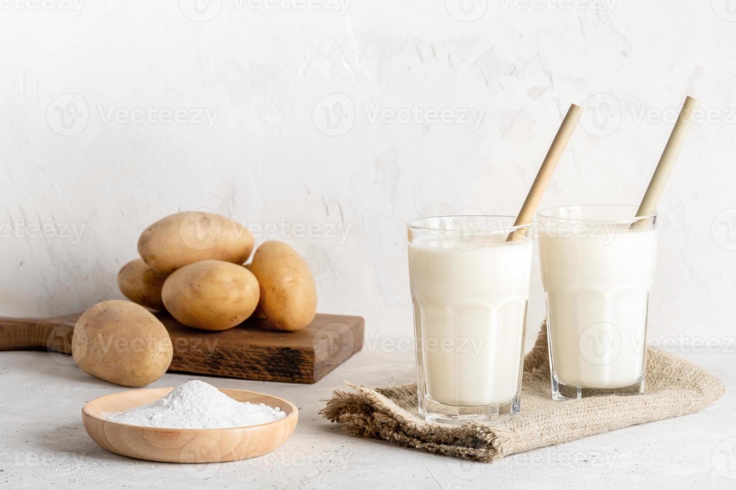 Powdered vegan potato milk in two glasses on neutral backdrop. Selective focus. photo