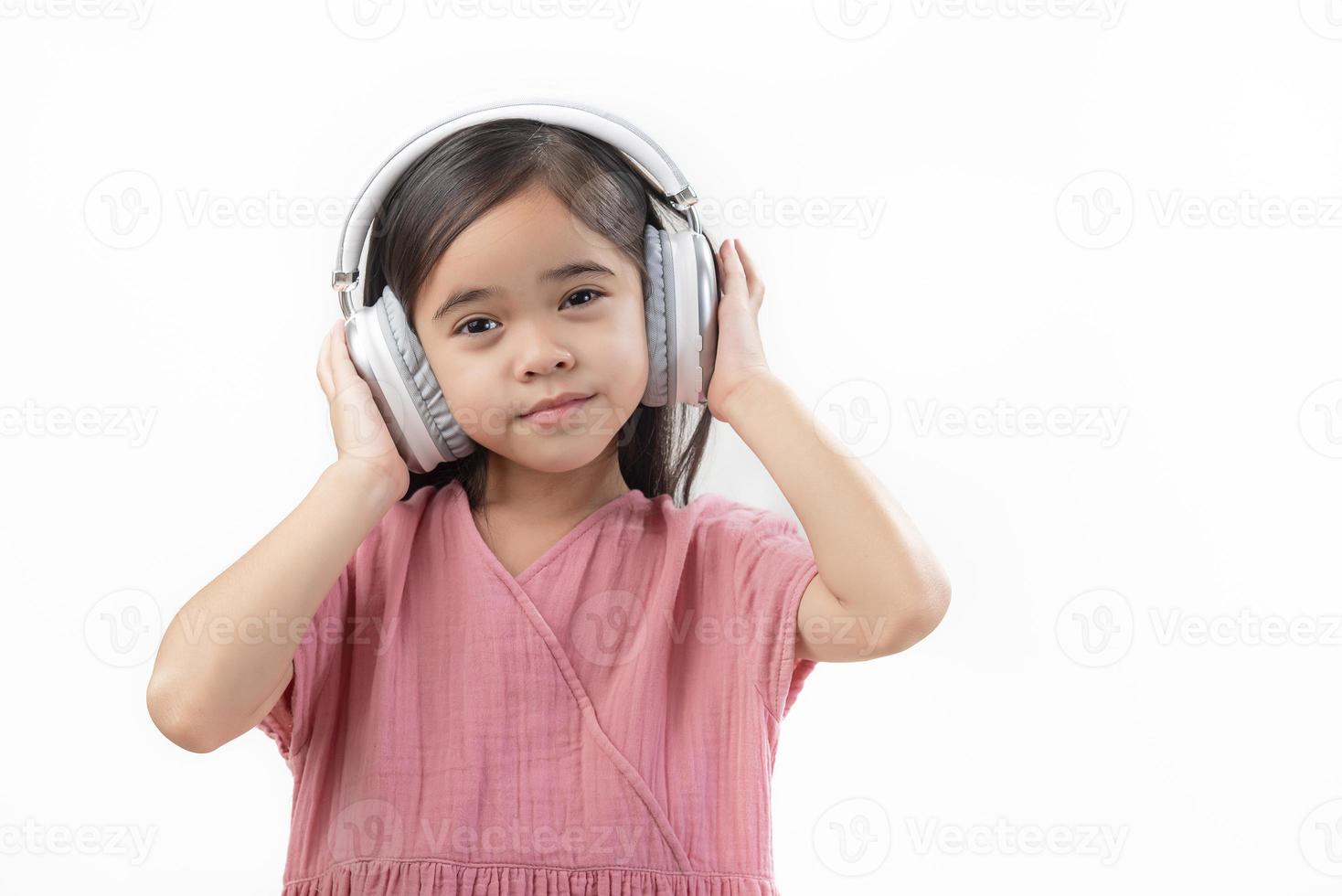 A little beautiful girl asia putting the headphone isolated on a white background. photo