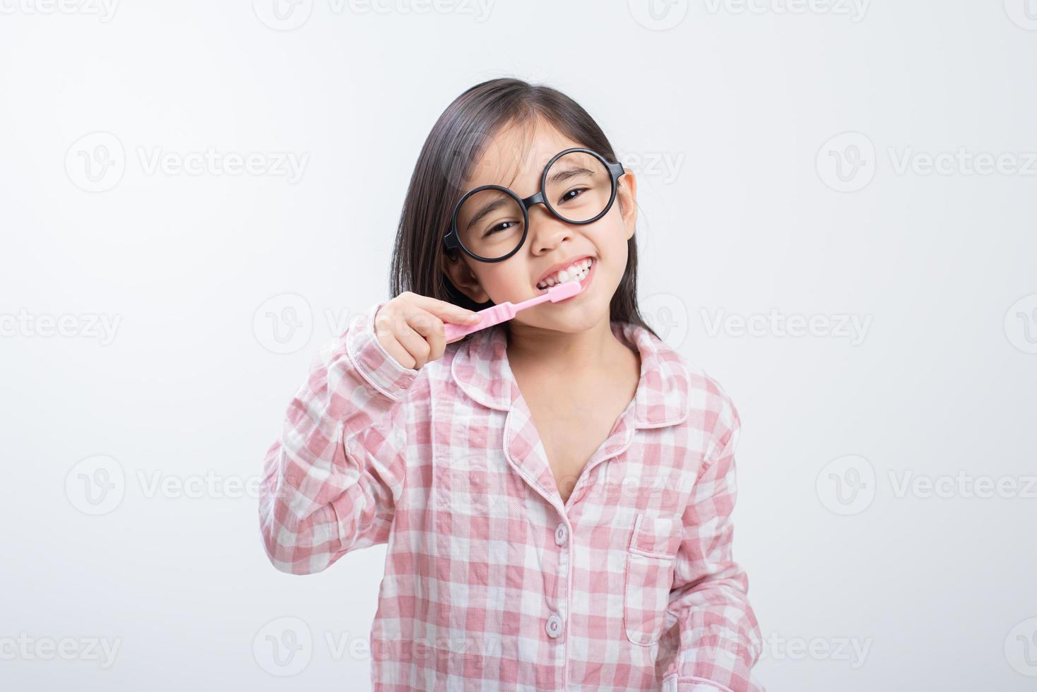 niña asia cepillarse los dientes felizmente fondo blanco foto