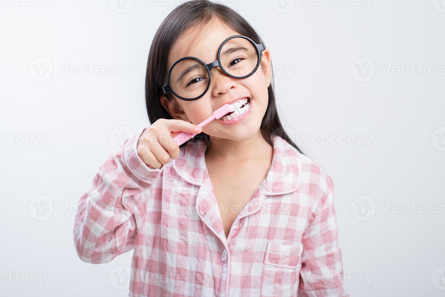 little girl Asia brushing teeth happily white background photo