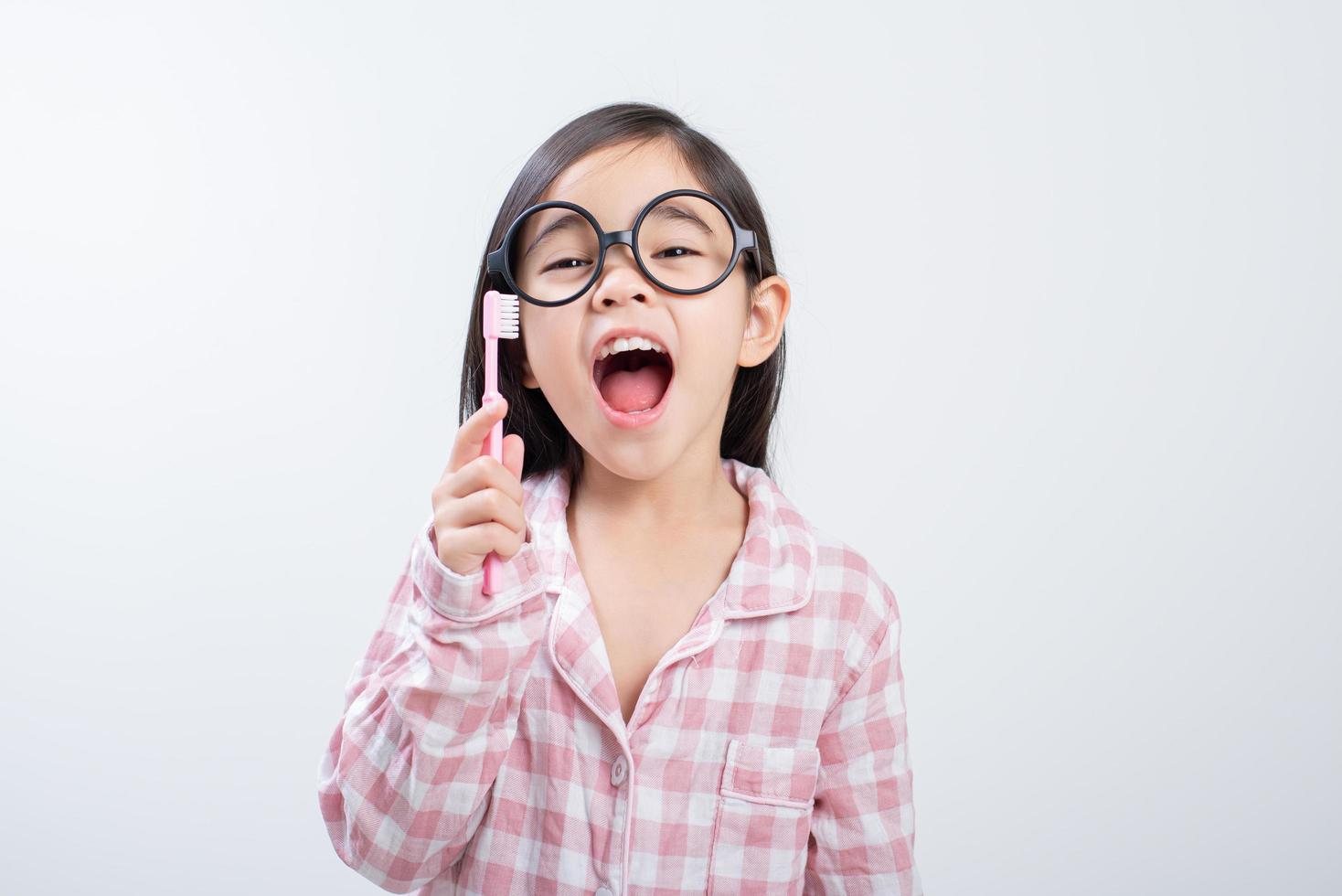 little girl Asia brushing teeth happily white background photo