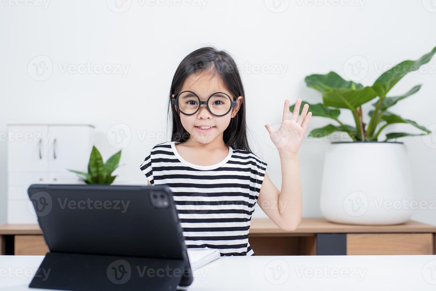 Asian child girl student wow excited on video call learning to studying online class or person learn from home school with tablet photo