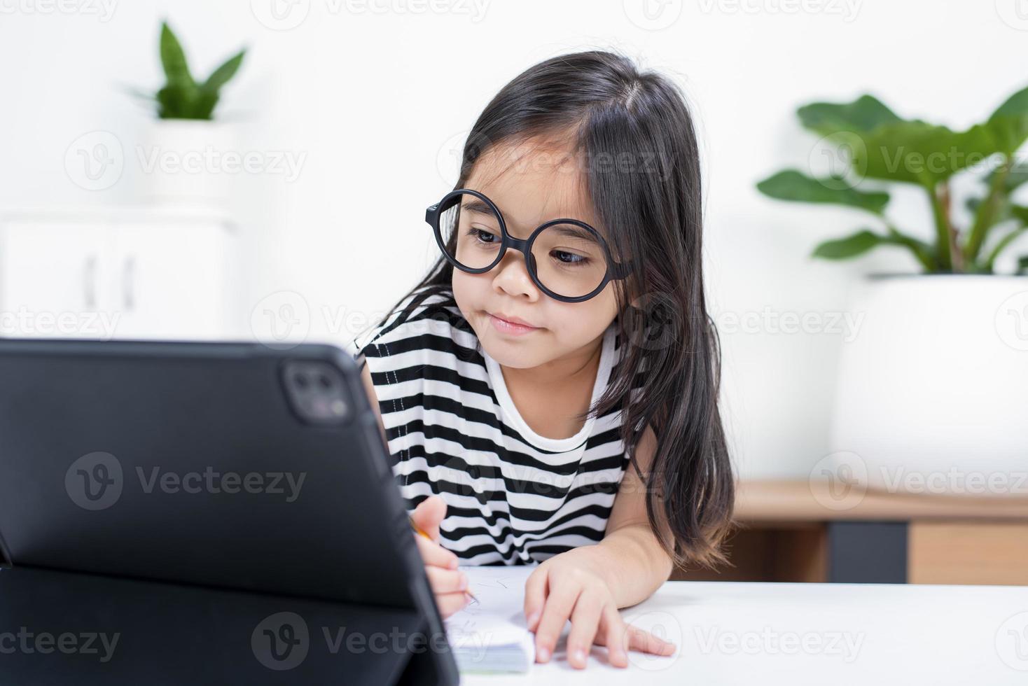 Asian child girl student wow excited on video call learning to studying online class or person learn from home school with tablet photo