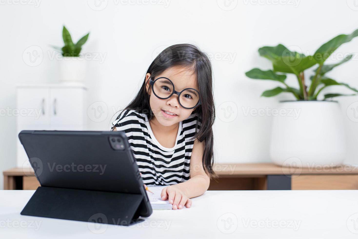 Asian child girl student wow excited on video call learning to studying online class or person learn from home school with tablet photo