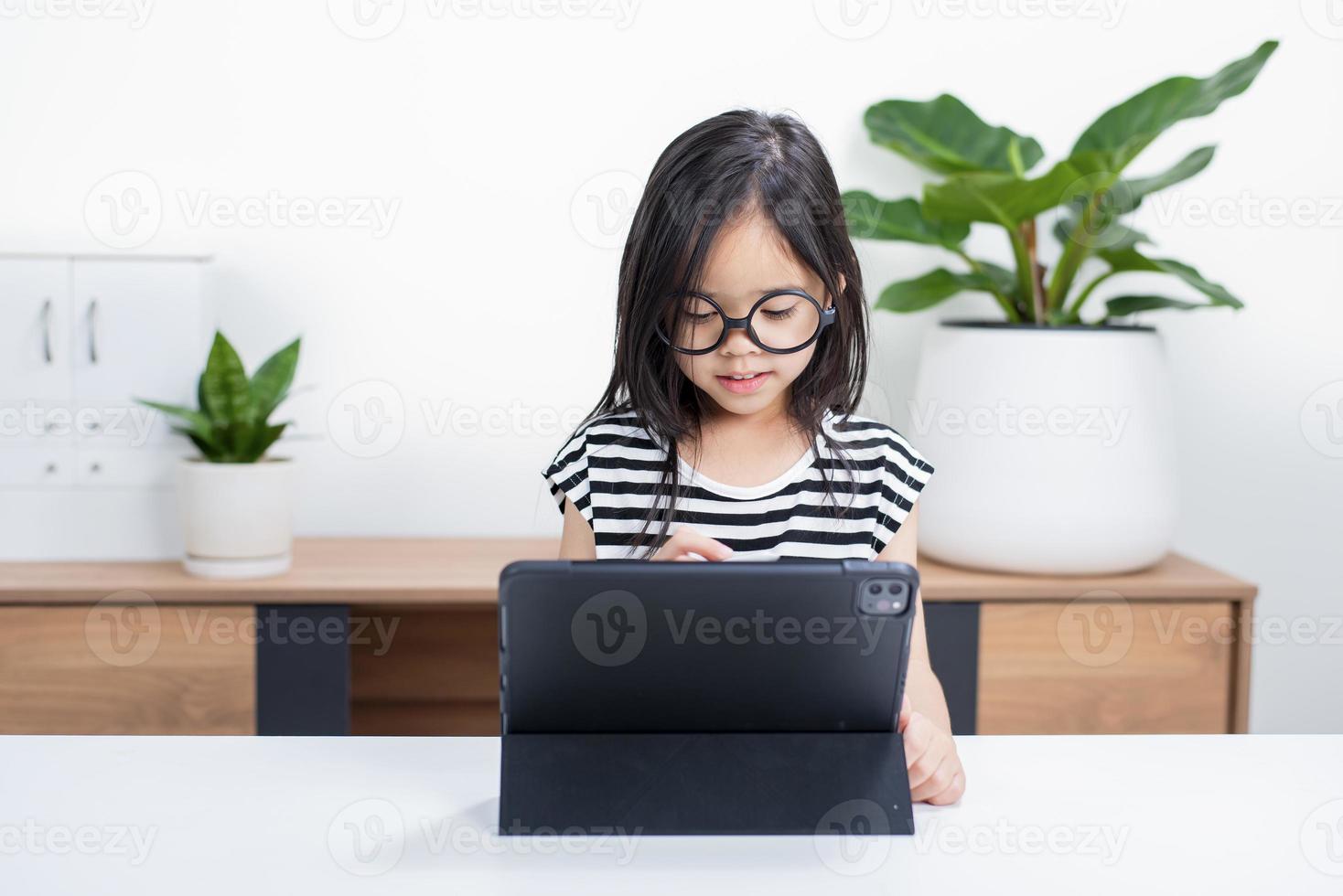 Asian child girl student wow excited on video call learning to studying online class or person learn from home school with tablet photo