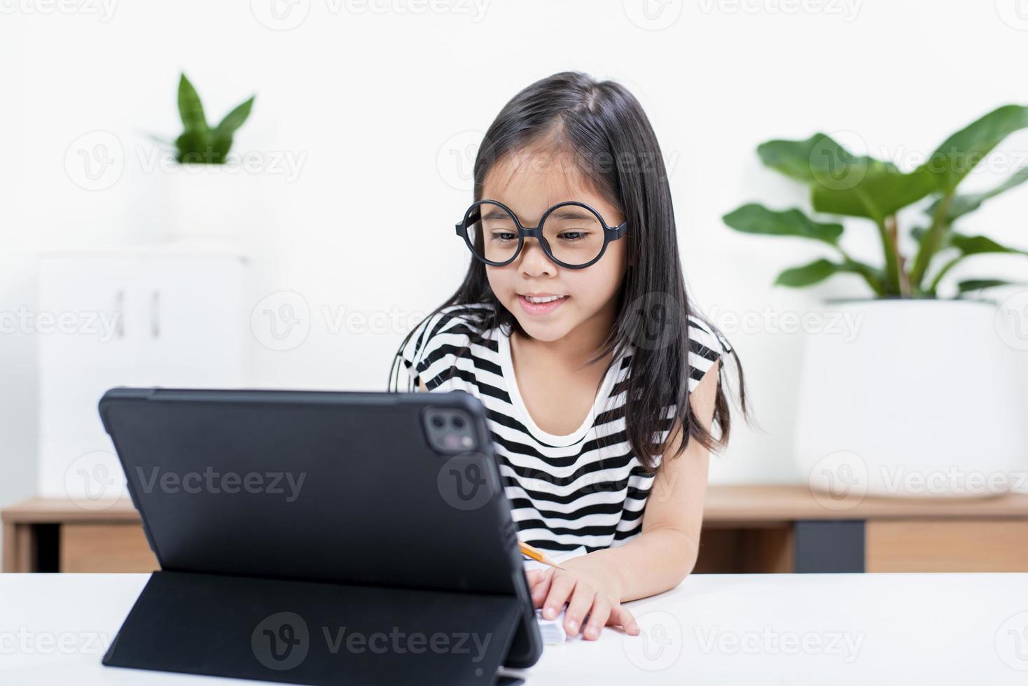 Asian child girl student wow excited on video call learning to studying online class or person learn from home school with tablet photo