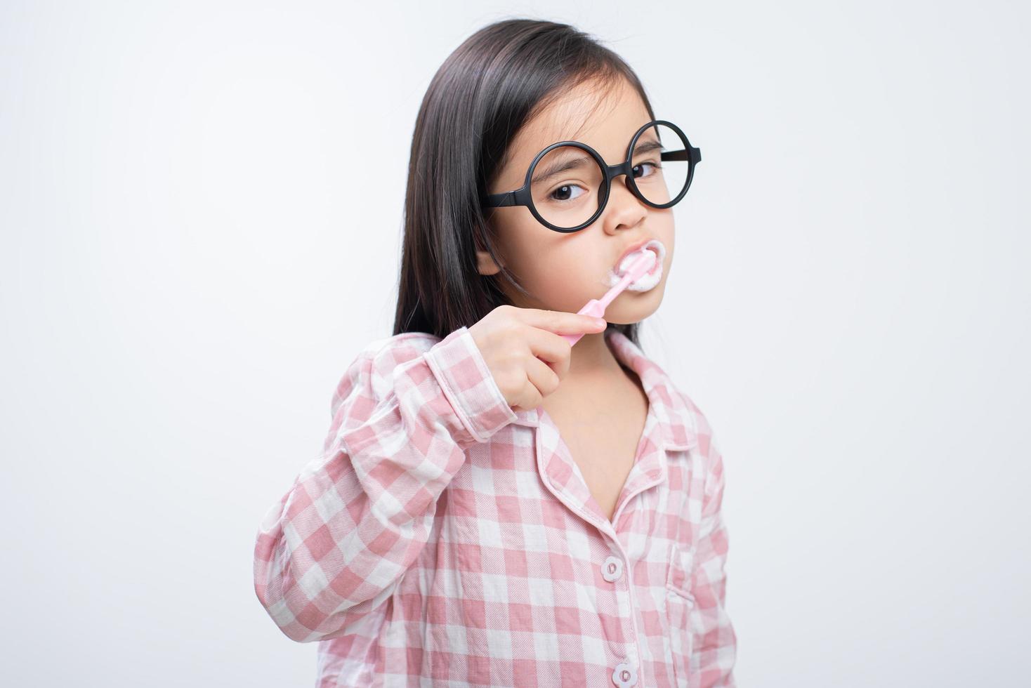 little girl Asia brushing teeth happily white background photo