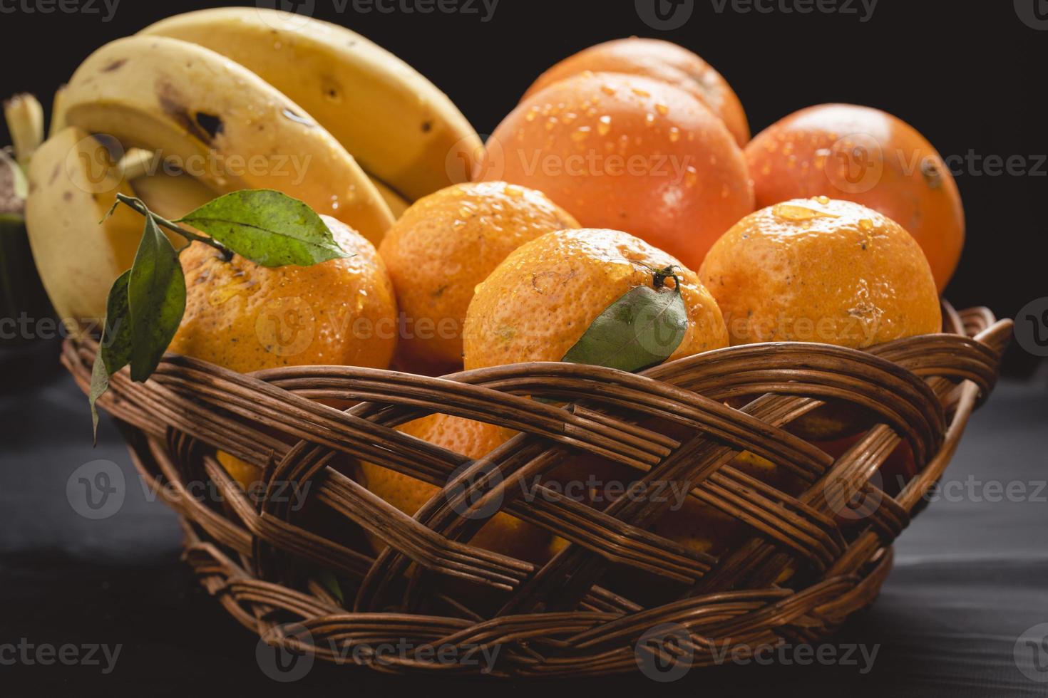 un plato de frutas frescas de invierno, plátano, naranja y mandarina foto