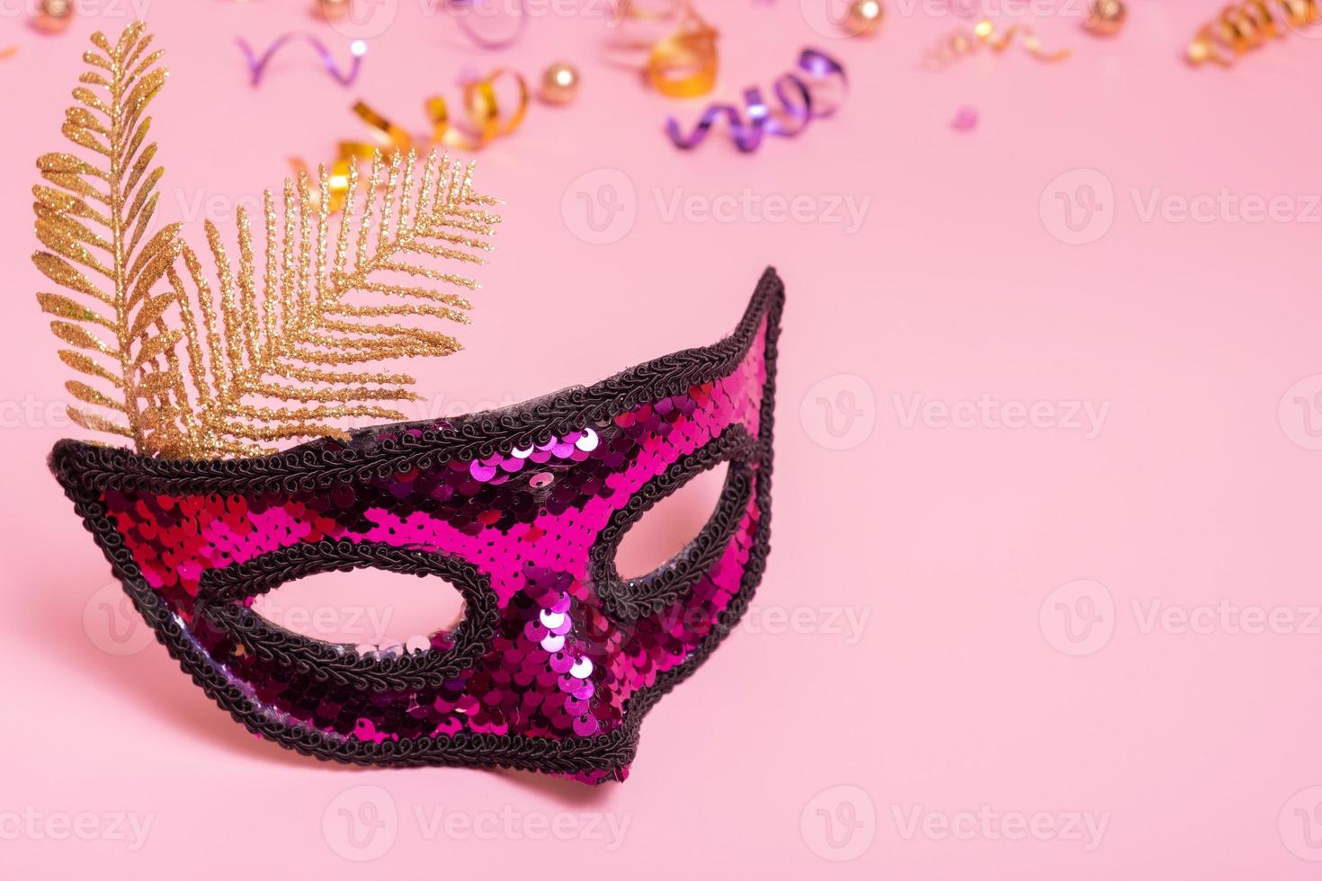 Festive face mask for masquerade or carnival celebration on pink background photo